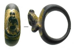 BAG-4092 - Bague avec buste : SarapisbronzeTPQ : 100 - TAQ : 300Bague coulée, chaton légèrement aplati, d'où émerge en haut-relief un buste de Sarapis, sous la forme d'un homme barbu, vêtement plissé couvrant le torse, coiffé du kalathos.