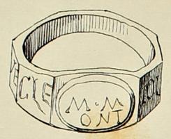 BAG-4384 - Bague à jonc octogonal et à chaton ovaleorTPQ : 150 - TAQ : 300Bague à jonc étroit de profil octogonal, aplati et élargi en une forme quadrangulaire pour recevoir un chaton rapporté de forme ovale. Une inscription votive incisée court sur les huit facettes du jonc.