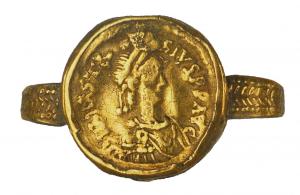 BAG-5022 - Bague monétaireorTPQ : 475 - TAQ : 725Bague monétaire composée d'une monnaie sous laquelle est soudé un jonc plat, parfois orné de chevrons sur toute sa longueur.