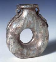 BLS-4130 - Aryballe annulaireverreAryballe de forme annulaire, le vase se développant sous la forme d'un tore circulaire, disposé verticalement et pourvu d'un col épaulé de deux petites anses plaquées.