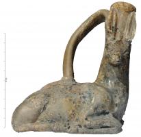 BLS-4135 - Balsamaire zoomorphe : bicheterre cuiteQuadrupède en terre beige, à vernis plombifère souvent très dégradé. Les pattes sont repliées et le cou recouvert d'un pelage en mèches épaisses ; la tête, tournée vers la droite, est surmontée d'un goulot étroit, entre lesquelles sont figurées deux longues oreilles plaquées sur le col. Une anse relie le sommet du col au milieu du dos.