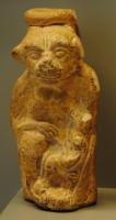 BLS-4137 - Balsamaire zoomorphe : guenon allaitantterre cuiteVase en forme de guenon assise, allaitant son petit posé sur sa jambe gauche ; col au sommet du crâne ; glaçure plombifère.