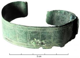 BRC-1120 - Bracelet platbronzeBracelet ouvert réalisé à partir de deux rubans de tôle de bronze soudés par leurs bords ; extrémités enroulées ; décor de courtes incisions transversales entre des séries de lignes parallèles aux bords, avec sur certains exemplaires des lignes de pointillés (arcs et droites formant des panneaux) sur la partie médiane.