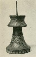 CHL-7007 - Chandelier à brochebronzeChandelier constitué de deux éléments superposés, une base tronconique et un sommet en forme de poulie, tous deux émaillés de motifs triangulaires et d'inspiration végétale; au sommet, broche verticale pour y piquer une chandelle.