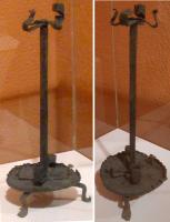 CHL-8002 - ChandelierferChandelier forgé, composé d'un pied en coupelle, à bord redressé, posé sur troix pieds rapportés, d'où sélève une hampe portant plusieurs bobèches ainsi qu'une pique terminale, où on peut ficher une chandelle. Nombreuses variantes.