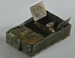 COF-4001 - Coffret à compartimentsbronzeCoffret en tôle, composé de plaques fixées entre elles par brasure, avec 4 ou 5 compartiments séparés par des cloisons verticales, et protégés par des couvercles pleins ou ajourés de carrés sur pointe, articulés sur deux ergots, avec de petites anses de préhension. L'ensemble est généralement protégé par un couvercle externe, coulissant dans des glissières.