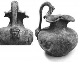CRU-4003 - Cruche à bec trilobé, type Eggers 125bronzeCruche basse, épaule marquée et col galbé terminé par une large ouverture trilobée ; l'anse s'élève plus haut que la lèvre et s'attache sur l'épaule par un médaillon figuré, parfois placé un peu plus haut sur l'anse (tête de femme, d'enfant, plus rarement une patte de lion). L'anse est ornée d'un protomé à tête de lion