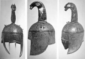 CSQ-2004 - Casque à cimier zoomorphebronzeCasque en tôle, avec l'emplacement du visage dégagé par une découpe rectangulaire entre deux couvre-joues formant une pointe de part et d'autre du menton; au-dessus, le timbre protégeant le crâne est rapporté par un sertissage faisant le tout de la tête ; au sommet, cimier vertical terminé par une tête de bélier projetée vers l'avant.