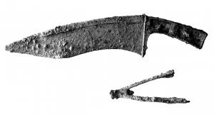 CTL-4001 - Coutelas à dos courbe et lame échancréefer, bronzeCoutelas à manche plat coulé directement sur la soie en fer; garde verticale protégeant la main au départ de la lame ; le dos prolonge le manche en une ligne courbe et le tranchant forme une ligne sinusoïdale caractéristique. Ces coutelas sont équipés de fourreaux à bouterolle, de même facture que ceux des glaives de type Mainz. 