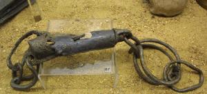 ENT-4012 - Entraves ferEntraves constituées d'un bloc-cadenas cylindrique, très allongé, auquel se rattachent deux anneaux formés d'une seule boucle ouverte, refermée sur elle-même.