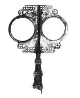 ESY-4001 - Enseigne de type FlobecqbronzeGrande enseigne à douille, constituée d'une large plaque percée de deux grands cercles autour d'une pointe; décor très soigné, avec tôles ajourées et petites figurines rapportées ; un chapiteau corinthien occupe le sommet de la pointe ; nombreuses incrustations de laiton sur le fer.