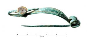 FIB-3512 - Fibule laténienne à pied discoïdal étroit orné de corailbronzeFibule à arc en anse de panier symétrique, section ronde ou ovale parfois très aplati, dans ce cas avec un décor longitudinal ; ressort à 4 spires (souvent de fort diamètre) et corde externe ; pied redressé vers l'arc et terminé par un disque percé pour fixation d'un décor de corail ou d'émail.