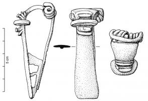 FIB-4049 - Fibule à ailettesbronzeType caractérisé par la présence, au sommet de l'arc, d'un groupe de moulures symétriques autour d'une nodosité ; les éléments extérieurs se replient comme des pétales ou des ailettes vers le disque ou la moulure centrale ; dans cette variante, l'arc est large et les ailettes encadrent un disque épais, parfois encoché. 