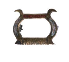 FIB-41044 - Fibule skeuomorphe : sciebronzeFibule en forme de scie à cadre, aux côtés arqués et émaillés ; sommets en crosse; les côtés sont émaillées et les dents de la lame sont figurées.