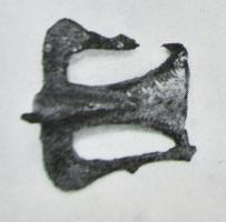FIB-41221 - Fibule zoomorphe : oiseaubronzeBroche en forme d'oiseau au corps plat, mais dont le cou et la tête se détachent en ronde-bosse; les ailes sont écartées et leurs extrémités rejoignent les pointes de la queue également déployée; deco a tremolo sur fond étamé.