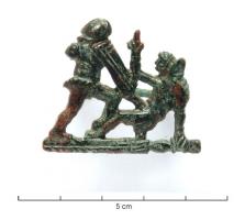 FIB-41352 - Fibule anthropomorphe : gladiateursbronzeFibule représentant une paire de gladiateurs, dans la phase la plus dramatique du combat : l'un des adversaires est tombé à terre, et lève un doigt pour demander grâce; l'autre, arme levée, est prêt à le transpercer si la décision publique va dans ce sens.