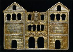 FIB-41373 - Fibule architecturale : porte de villeargentBroche représentant une porte urbaine, avec au centre sa double arcade surmontée de deux rangées de fenêtres, au centre de la rangée sommitale un buste tourrelé (Tutela); de part et d'autre, tours avec une entrée au rez-de-chaussée et deux rangs de fenêtres aux derniers niveaux; objet doré.
