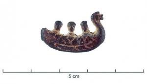 FIB-4149 - Fibule skeuomorphe : bateaubronzeFibule étamée et niellée en forme de bateau : barque à rames, figure animale à la proue, 3 rameurs ou passagers.