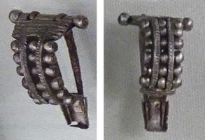 FIB-41737 - Fibule de type Bagendon à deux ardillonsargentFibule à charnière, arc double formant un arc de cercle, reliés par des axes transversaux portant des perles ; aux deux ardillons juxtaposés correspondent deux gouttières, placées de part et d'autre du pied simplement aplati.