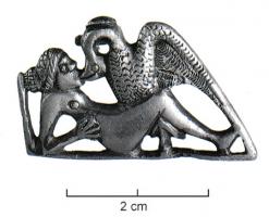 FIB-41742 - Fibule zoomorphe, groupe : Leda et le cygneargentFibule en relief plat, les détails indiqués par des incisions: Leda, couchée sur le dos, appuyée sur un coude, s'unit au cygne qui l'embrasse en déployant ses ailes.