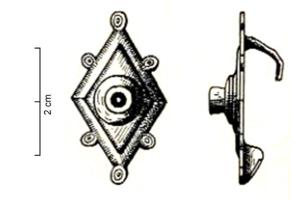 FIB-41880 - Fibule losangique émailléebronzeFibule à arc losangique dont la partie centrale en surplomb est surmontée par une loge circulaire émaillée. La plaque losangique est incisée sur son pourtour, et est accostée de boutons décorés d'ocelles ; au revers, articulation à charnière entre deux plaquettes; haut porte-ardillon en crochet.