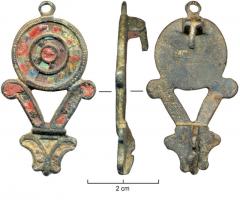 FIB-4211 - Fibule non symétrique émaillée avec anneaubronzeFibule non symétrique, à décor émaillé, surmontée d'un petit anneau. Corps circulaire creusé de trois loges d'émail concentriques, avec inclusions de verre, surmontant un cadre triangulaire vide formé de deux crosses au-dessus d'un motif formé de deux pétales.