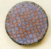 FIB-4276 - Fibule circulaire émaillée en millefioribronzeFibule discoïdale dont le disque pourvu d'un petit rebord reçoit un semi continu de millefiori, disposés en damier. Au revers, articulation à ressort (sur une plaquette) ou à charnière (sur deux plaquettes).