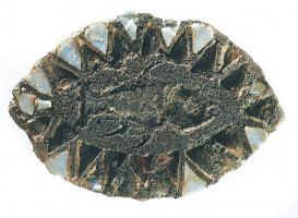 FIB-4599 - Fibule émaillée : poissonbronzeBroche ovale, à ressort en fer monté sur une seule plaquette; forme de mandorle, avec un pourtour émaillé de triangles de couleurs alternées, encadrant une figure animale (poisson, quadrupède...).