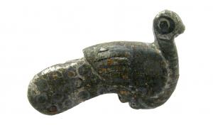 FIB-4648 - Fibule zoomorphe : paonbronzeBroche plate, étamée, figurant un paon assis, les plumes indiquées par des incisions réalistes sur les ailes, de simples arcs de cercles (parfois niellés) sur la queue.