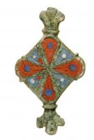 FIB-4704 - Fibule symétrique émailléebronzeFibule symétrique émaillée, avec un  corps central losangique creusé de qatre pétales émaillés; aux extrémités, appendices symétriques en forme de fleurons.