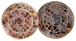 FIB-5054 - Fibule cloisonnée discoïdale, groupe Vielitz Hor, argentFibule en or composée d'un cloisonné complexe dessinant une croix centrale, incrustée de grenats. Groupe hétérogène aux décors cloisonnés différents. Les fibules de ce groupe sont toutes rondes, avec un support en or ou alliage cuivreux (diam. 34-50 mm).