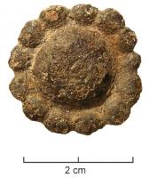FIB-6104 - Fibule en forme de rosettebronzeFibule circulaire, dont la surface interne peut être légèrement bombée ou non, comportant sur tout le pourtour un alignement de larges globules.