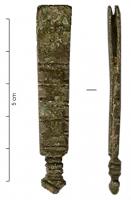 FRT-7014 - Ferret de ceinturebronzeTPQ : 1350 - TAQ : 1500Ferret à corps rectangulaire composé de deux lamelles émergent d'une base coulée, et réunies par un rivet sommital, souvent en fer; la base un peu plus épaisse est marquée d'encoches quadrangulaires, la face supérieure ornée d'incisions transversales.