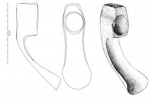 HRM-4005 - HerminetteferTPQ : 1 - TAQ : 400Herminette à douille cylindrique courte, d'où émerge latéralement une lame inclinée vers le bas. Son tranchant est nettement incurvé. Présence d'un embryon de surface de frappe dont la table est de section rectangulaire. L’œil est circulaire. 