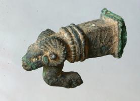 IND-4161 - Manche ? avec tête de bélier et crochetbronzeManche ou décor, formé d'une gaine de section carrée, encadrée de groupes de moulures, terminée par une tête de bélier sous laquelle émerge un robuste crochet.