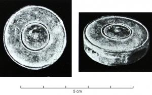 JHA-4048 - Passant de harnaisbronzePassant de harnais circulaire, face externe ornée de moulures concentriques, avec, dans la tranche, quatre ouvertures latérales pour des sangles se croisant à angles droits.