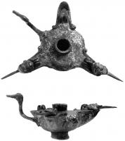 LMP-3001 - Lampe à trois becsbronzeLampe en bronze à trois becs et suspension centrale; trois crochets en S, terminés par des têtes d'anatidés stylisées, occupent les espaces entre les becs. Chaque bec est par ailleurs protégé par un petit couvercle articulé, en forme de tête de Silène (masque de théâtre ?), prolongé par une pointe effilée qui sert sans doute à les manipuler.