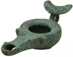 LMP-4018 - Lampe à anse annulaire surmontée d'un croissantbronzeLampe à réservoir cylindrique à ouverture centrale, bec allongé, anse en anneau surmontée d'un croissant; deux ergots encadrent le bec allongé.