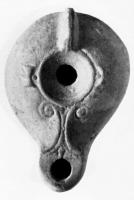 LMP-4081 - Lampe syro-palestinienneterre cuiteLampe à bec en ogive orné de volutes en relief; disque nu; épaule ornée de deux ergots; anse non percée.