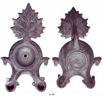 LMP-41186 - Lampe Loeschcke III à deux becsterre cuiteLampe ronde à double bec à volutes avec terminaison en ogive et tête de cheval à la fin de chaque volute, sur le côté. Médaillon vierge. Anse plastique en forme de feuille d'acanthe.