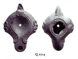LMP-41192 - Lampe Loeschcke IV tardiveterre cuiteLampe à long bec en ogive et demi-volutes. Bec à canal. Oreillettes latérales. Anse percée. Médaillon vierge.
