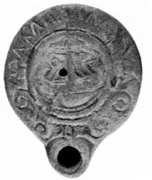 LMP-4134 - Lampe syro-palestinienne Loeschcke VIIIterre cuiteLampe à bec rond. Médaillon décoré d'un motif mal définissable (navire?), épaule ornée de volutes complètes surmontant le bec bec et de rayons sur le reste. 