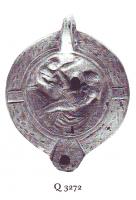 LMP-41432 - Lampe Loeschcke VIII : Scène érotique NEIKANDROUterre cuiteLampe ronde à bec rond défini par deux traits obliques. Médaillon décoré d'une scène érotique. Deux tenons en bas relief sur l'épaule, décorée d'une couronne de laurier. Marque NEIKANDROU en relief sur la base.