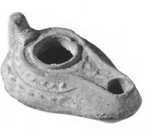 LMP-41491 - Lampe byzantine terre cuiteLampe allongée à long bec avec canal, épaule décorée de motifs géométriques et petite anse conique.