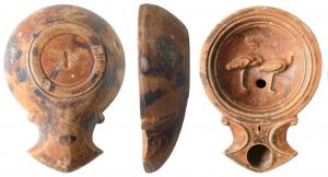 LMP-41519 - Lampe Loeschcke IB : Echassiersterre cuiteLampe moulée, sans anse. Réservoir circulaire de profil tronconique. Bandeau étroit plat. Disque en profonde cuvette, limité par trois sillons concentrique décorée de deux échassiers à droite . Bec triangulaire à deux volutes se poursuivant sous le bec, trou d'évent. Base en anneau plat, planta pedis au centre. Engobe rouge brique .