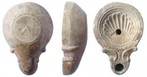 LMP-41530 - Lampe Loeschcke IV : Coquillageterre cuiteLampe moulée, sans anse. Réservoir circulaire de profil convexe. Bandeau étroit penché vers l'extérieur. Disque en cuvette lilmitée par deux cercles concentriques. Décor : coquille  St Jacques à douze cannelures. Bec long en ogive flanqué de deux volutes doubles se poursuivant sous le bec. Trou d'évent. Base plate limitée par un sillon, portant un V en relief à l'envers. Engoge gris marron.