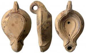 LMP-41546 - Lampe à volutes dégénéréesterre cuiteAnse percée à trois sillons, moulée avec la lampe. Réservoir piriforme de profil biconvexe asymétrique. Bandeau penché vers l'extérieur. Disque limité par un sillon, en forme de larme,  décoré d'un sillon. Trou d'évent. Bec long arrondi à petit canal, à volutes dégénérées se poursuivant sous le bec. Base en forme de larme limitée par un sillon. Restes d'engobe marron foncé sur toute la lampe  