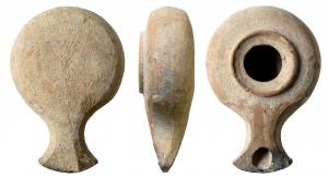 LMP-41558 - Lampe hérodienneterre cuiteTournée, sans anse. réservoir circulaire de profil globulaire. Large rebord, disque en anneau plat limité par un fin bourrelet autour d'un grand trou d'alimentation. Bec rapporté, étroit, au bout en large bras d'ancre. Base plate non délimitée.