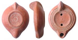 LMP-41652 - Lampe africaine sans canal : ...EXOterre cuiteLampe moulée, anse verticale pleine. Réservoir circulaire de profil biconvexe. Trois sillons continus sur le bandeau. Disque en simple cuvette, petit cercle en creux au centre. Petit bec arrondi limité par deux arcs de cercles gravés. Base plate en relief, limitée par un bourrelet ; série de sillons concentriques. Engobe rouge.
