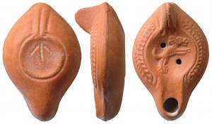 LMP-41666 - Lampe Hayes I : Chienterre cuiteLampe moulée, anse verticale pleine à un sillon, faisant avec la patère une excroissance caractéristique du type. Réservoir piriforme de profil biconvexe. Palmes descendantes sur le bandeau. Bec allongé et grand disque  entourés par un bourrelet : chien bondissant à droite. Base plate limitée par un bourrelet formant une patère avec un double bourrelet rejoignant l'anse. Porte une flèche gravée Engobe rouge brique.
